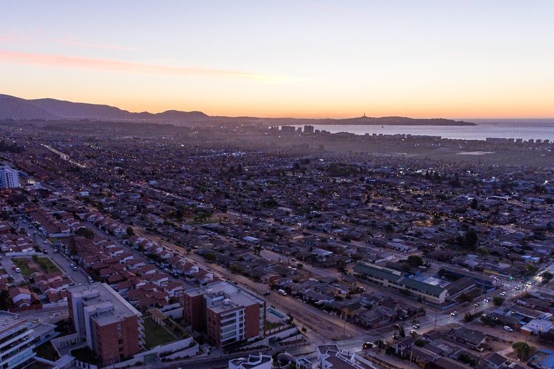 Vista a&eacute;rea de barrios residenciales de La Serena al atardecer, con la costa al fondo